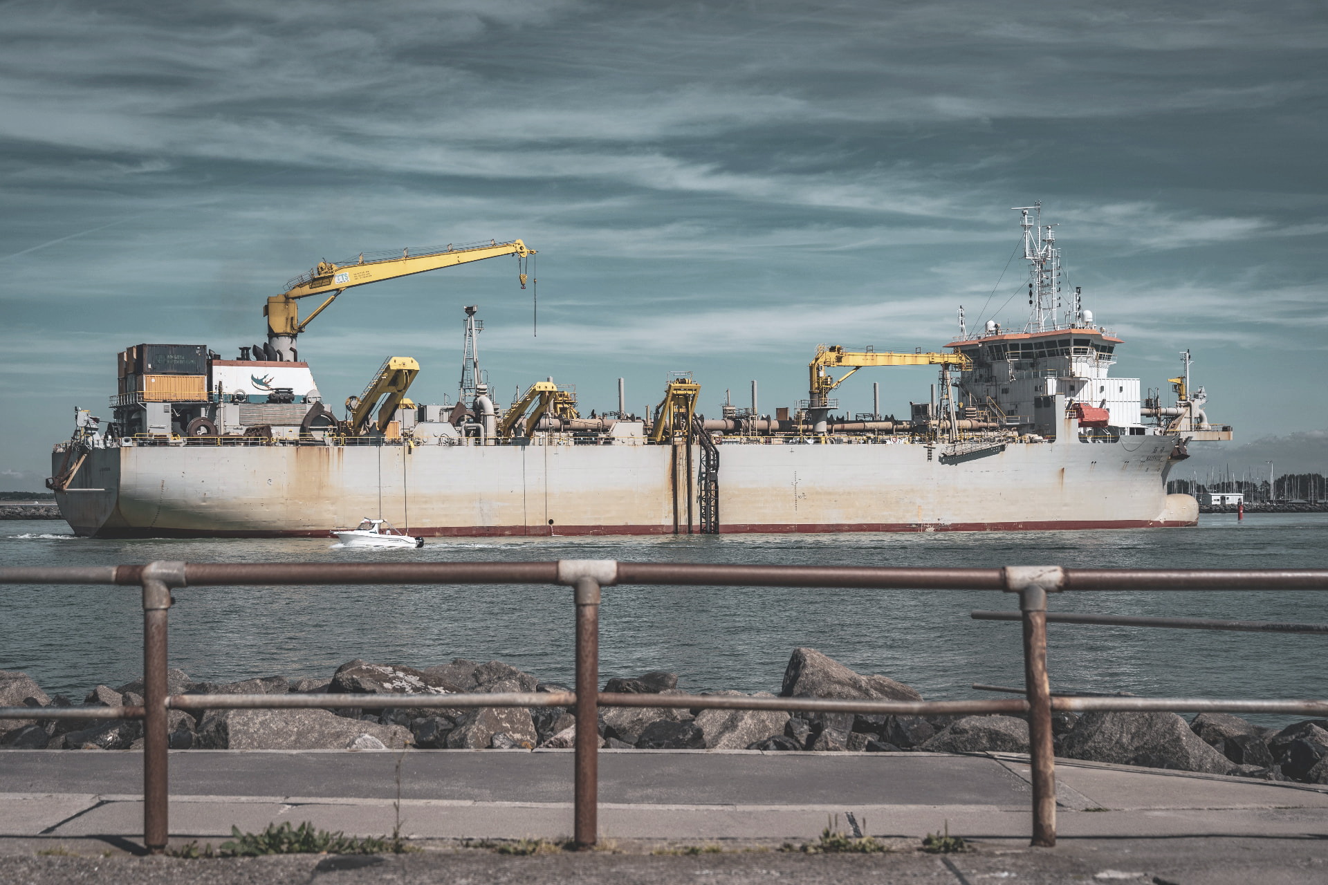 Serviceschip met dekkranen onderweg nabij een haven